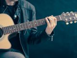 Spazio etico di seduta e oggetti chiari da suonare per il principiante di chitarra classica